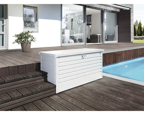 Fotografi av en vit förvaringslåda i metall på en terrass bredvid en pool.