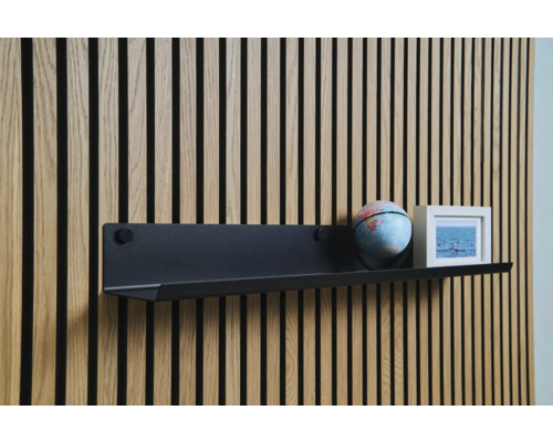 Vägghylla med jordglob och fotoram på träpanelvägg