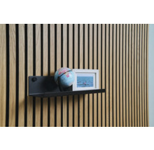 Dekorativ väggdesign med träpaneler, hylla, jordglob och fotoram