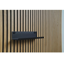 Svart hylla på en träpanelvägg