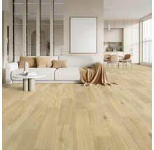 Ljust vardagsrum med trägolv, soffa, bord och köksdel.