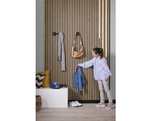 Hall med träpanelvägg, klädkrokar och barn