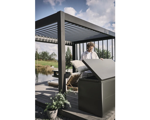 Man förvarar kuddar i en förvaringslåda utomhus under en pergola.