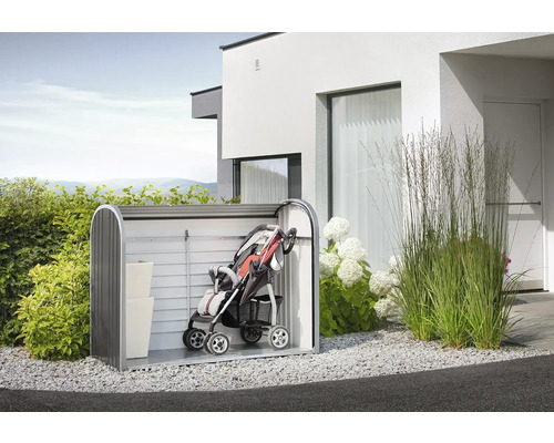 Trädgårdsscen med redskapsbod med barnvagn och förvaringslådor framför ett hus