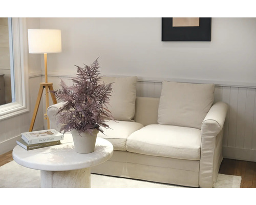 Scen med soffa, golvlampa, bord och krukväxt för inredning