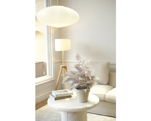 Dekorativ konstgjord växt på ett sidobord i ett vardagsrum.