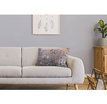 Dekorativt vardagsrum med soffa, prydnadskudde och trämöbler