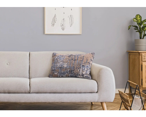 Dekorativt vardagsrum med soffa, prydnadskudde och trämöbler