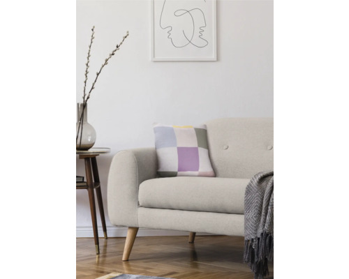 Vardagsrum med soffa, kudde, sidobord och dekoration