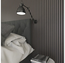 Sovrum med säng, vägglampa och väggpaneler