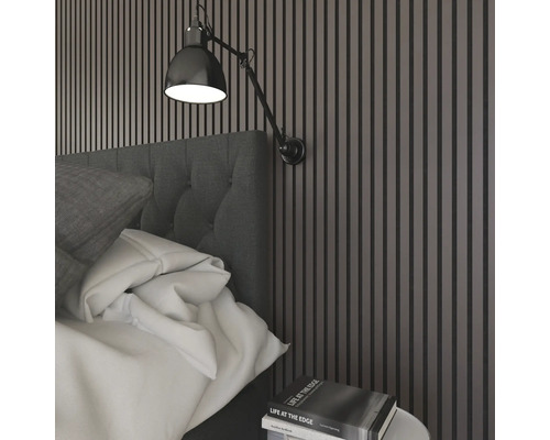 Sovrum med säng, vägglampa och väggpaneler