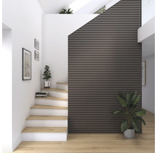 Interiörbild av ett trapphus med trätrappor, väggpaneler och krukväxter för en vänlig atmosfär