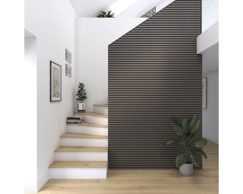 Interiörbild av ett trapphus med trätrappor, väggpaneler och krukväxter för en vänlig atmosfär