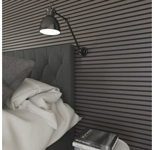 Sovrum med väggpaneler, säng, sängbord och lampa