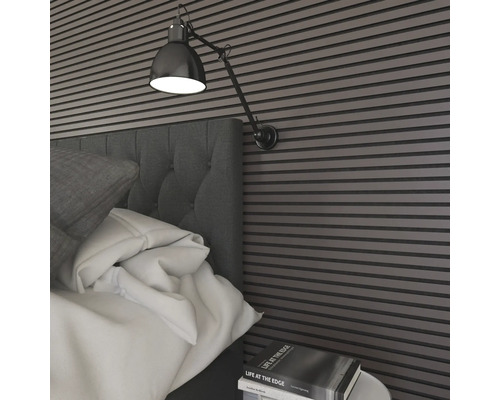 Sovrum med väggpaneler, säng, sängbord och lampa