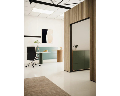 Ljust kontor med skrivbord, kontorsstol, byrå och väggpaneler