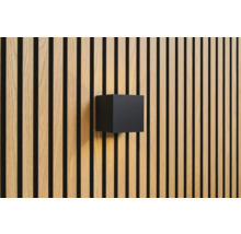 Kubformad vägglampa på träpanelvägg