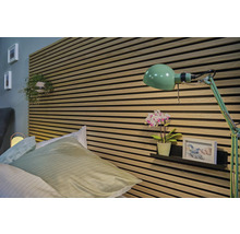 Sovrum med säng, väggpaneler och grön lampa