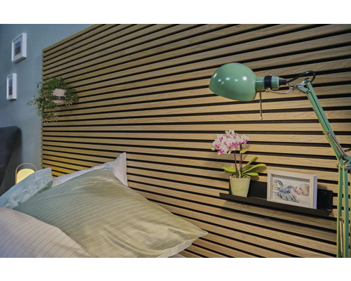 Sovrum med säng, väggpaneler och grön lampa