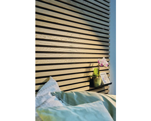 Sovrum med träpanelväggar och en hylla med dekoration