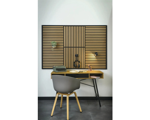 Inredning med skrivbord, stol och akustikpanel på väggen.