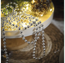 Dekoration med silverfärgad kulkedja på en bricka