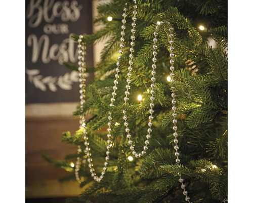 Julgran med silverfärgad pärlkedja som dekoration