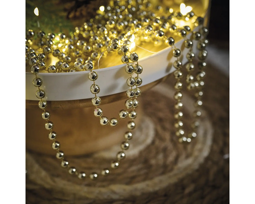 Guldfärgad pärlkedja för dekoration i en skål