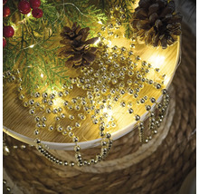 Dekoration med grangrenar, kottar och guldfärgad kulkedja