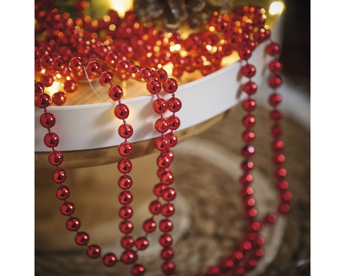 Dekoration med röda kulor på ett snöre