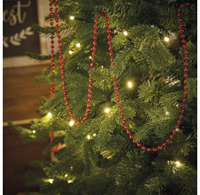 Dekorerad julgran med röd pärlkedja och belysning