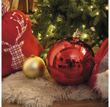 Juldekoration med julgranskulor, presentsäck med hjortmotiv och ljusslinga under julgranen