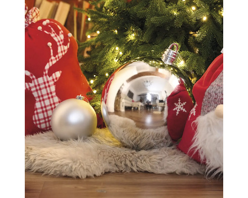 Dekorativ julscen med julgranskulor, presentsäckar och en ljusslinga under en julgran