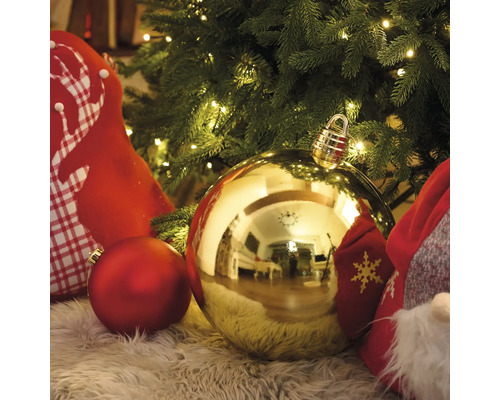 Scen med julgranskulor och dekorationer på en matta under en julgran