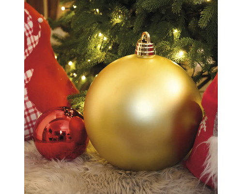 Guldfärgade och röda julgranskulor under en julgran