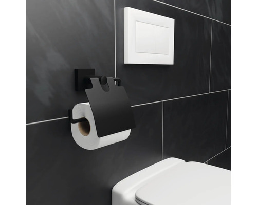 Svart toalettpappershållare med toalettpappersrulle på en badrumsvägg