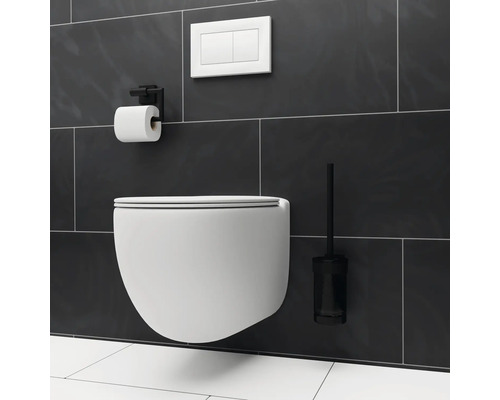 Vägghängd toalett med toalettborste, cistern och toalettpappershållare i ett badrum