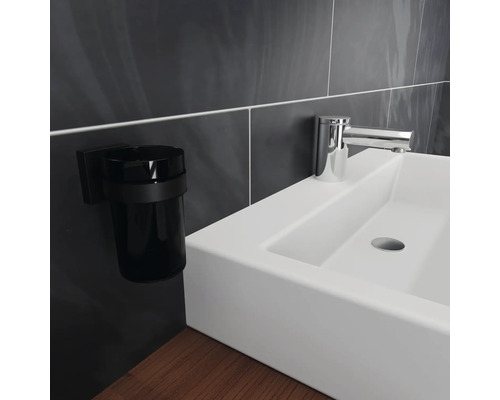 Tvättställ med kran och tandborstmuggshållare i badrummet