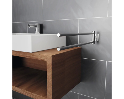 Modernt badrum med handfat, armatur och vridbar handdukshängare