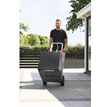 Man transporterar låda med en pirra utomhus.