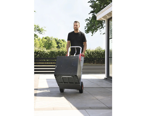 Man transporterar låda med en pirra utomhus.