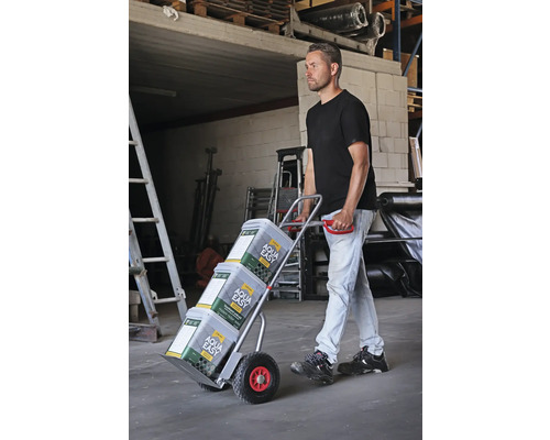 Man transporterar färgburkar med en säckkärra