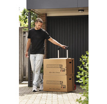 En person drar två Hornbach flyttkartonger med vagnfunktion på en asfalterad väg.