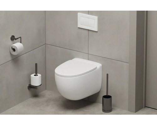 Modernt badrum med vägghängd toalett, toalettpappershållare och toalettborste