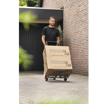Man transporterar Hornbach-kartonger på en säckkärra