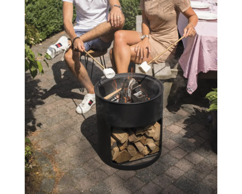 Människor sitter runt en eldstad och håller marshmallows över lågorna