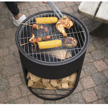"En kolgrill med grillad mat som kyckling, majskolvar och köttspett vänds med en grilltång