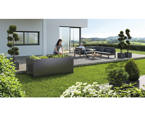 Trädgårdsscen med planteringslåda, planterad, och sittande person på en bänk