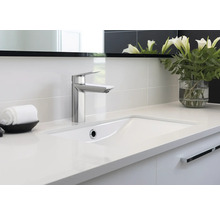 Modern badrum med handfat, kran, handduk och blomvas