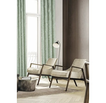 Vardagsrum med gardin, två fåtöljer, golvlampa och soffbord